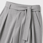 Grey men's wide-leg pleated trousers waistband and pleat detail