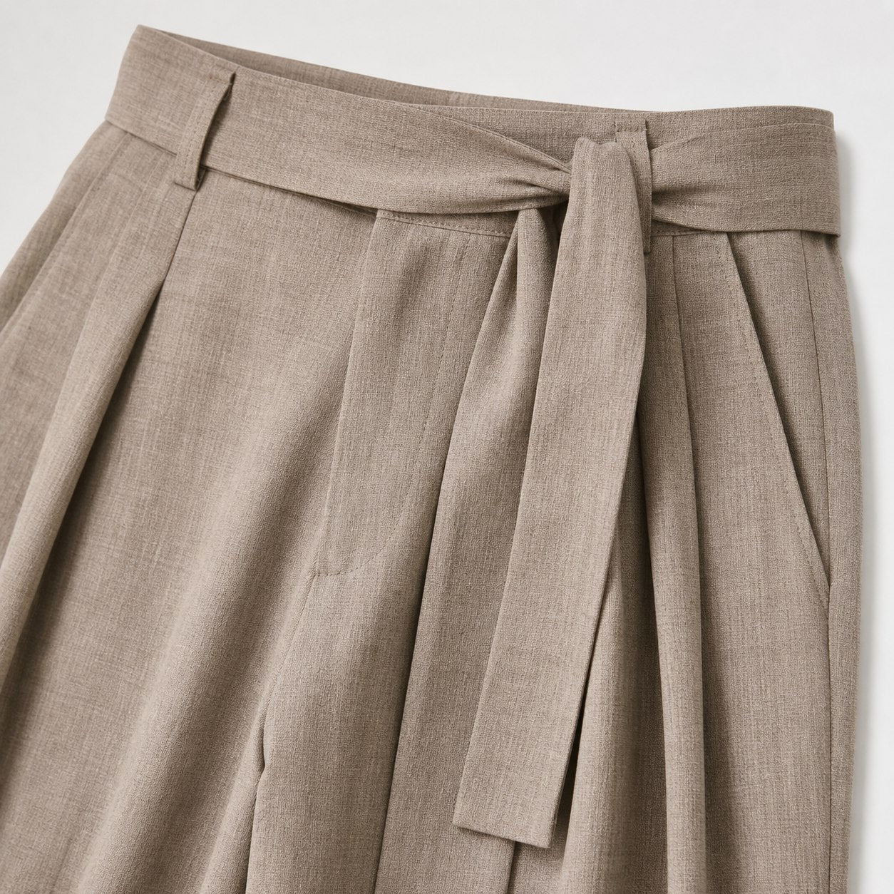 Khaki men's wide-leg pleated trousers waistband and pleat detail